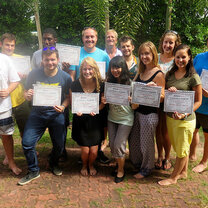 Get TEFL certified and teach in Thailand with Greenheart Travel group standing with certification papers